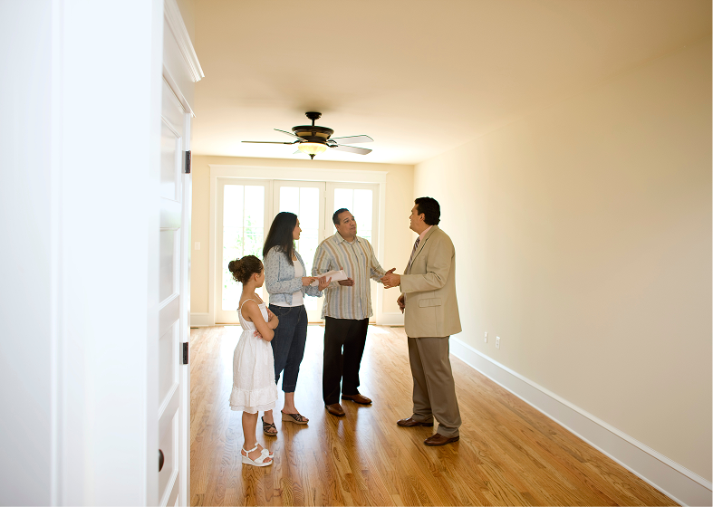 Family touring empty new home with agent