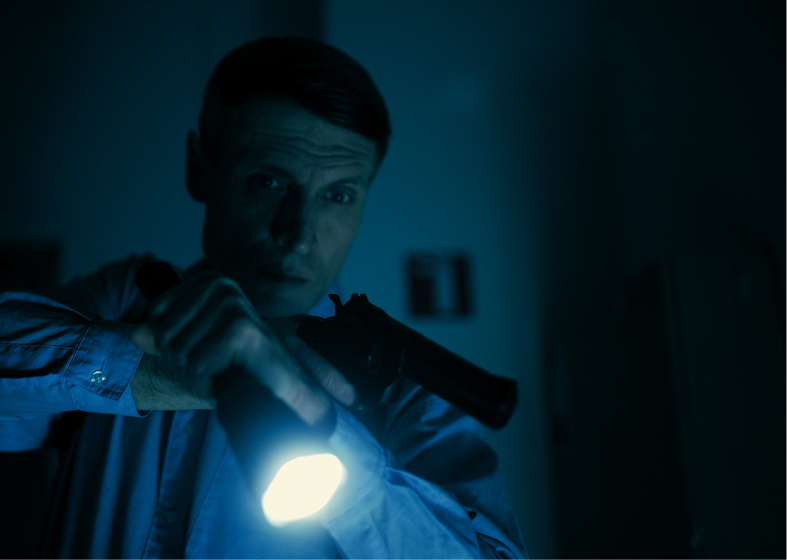 Man holding flashlight in dark room