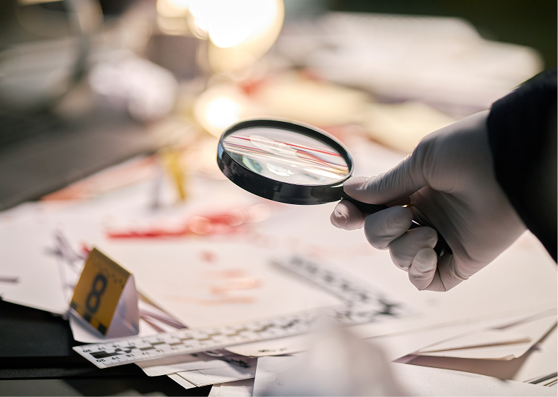 Investigator examining documents with magnifying glass