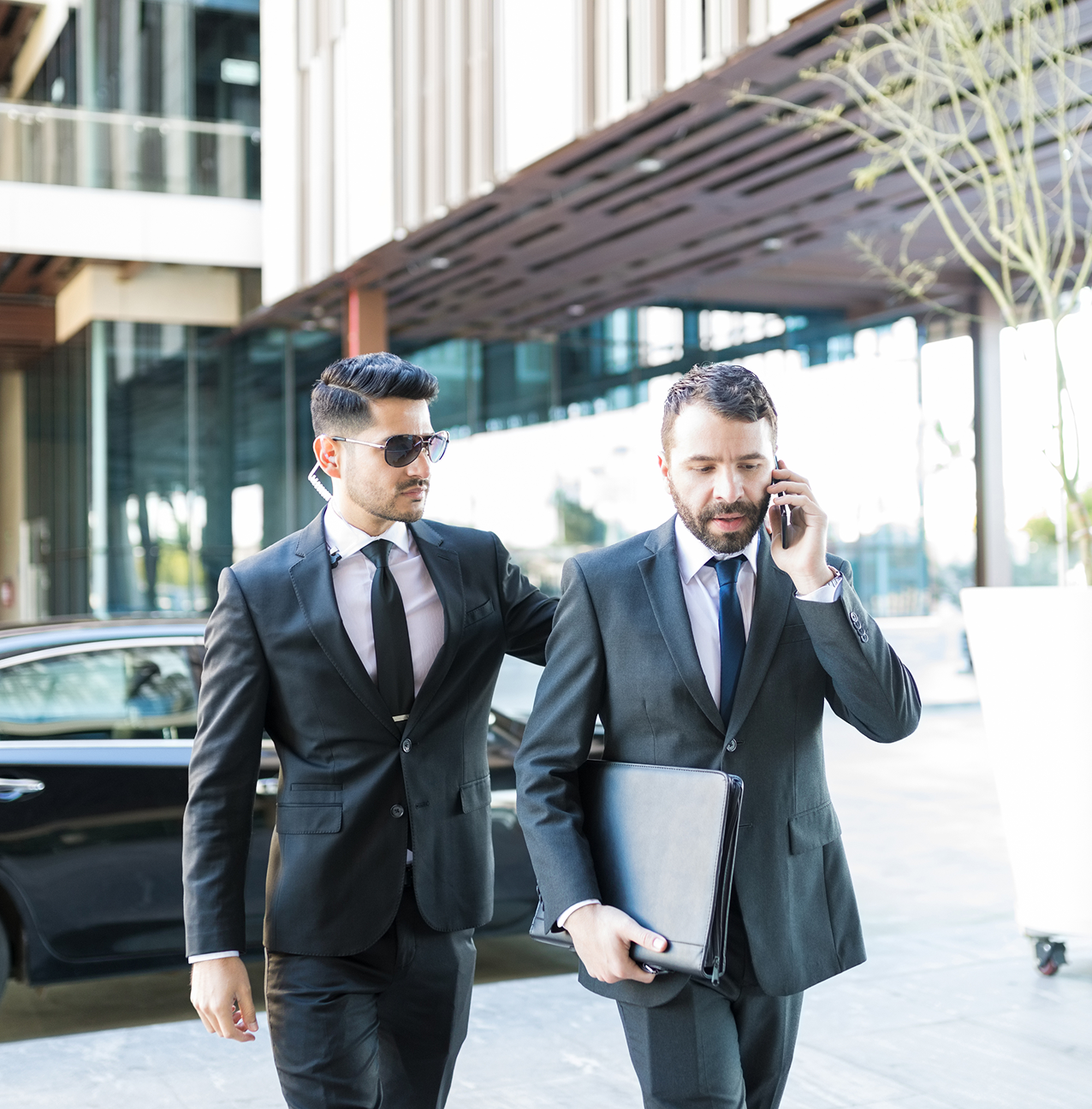 Two businessmen walking outside office building.